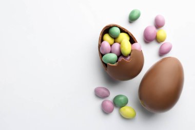 Beyaz arka planda çikolatalı Paskalya yumurtaları ve şekerler. Metin için boşluk