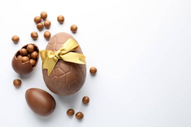 Beyaz arka planda çikolatalı Paskalya yumurtaları ve şekerler. Metin için boşluk