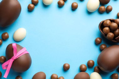 Açık mavi arkaplanlı çikolatalı Paskalya yumurtaları. Metin için boşluk