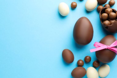 Açık mavi arkaplanlı çikolatalı Paskalya yumurtaları. Metin için boşluk