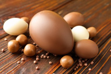 Ahşap masada şekerli çikolatalı yumurtalar, yakın plan. Mutlu Paskalyalar