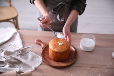 Geleneksel Paskalya pastasını mutfakta jöleli dekore eden genç bir kadın.