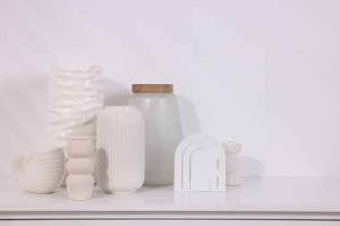 Işık duvarının yanındaki beyaz masada bir sürü şık vazo var. Metin için boşluk