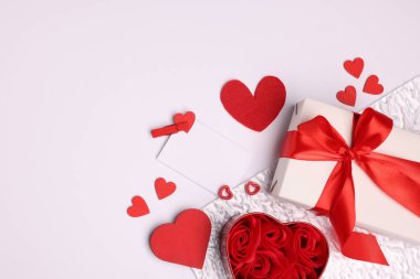 Güzel güller, romantik hediyeler ve beyaz arka planda dekoratif kalpler. Metin için boşluk