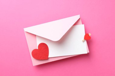 Tebrik kartı ve pembe arka planda dekoratif kalp ile zarf, üst görünüm