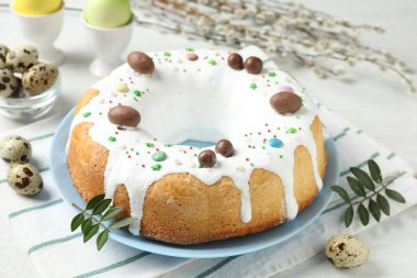 Lezzetli Paskalya pastası, söğüt dalları, bıldırcın ve beyaz masaya boyanmış yumurtalar, yakın plan.