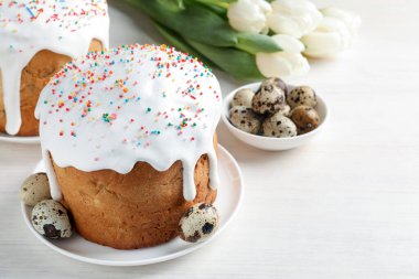 Güzel Paskalya pastaları, yumurtalar ve laleler beyaz masada, yakın plan.