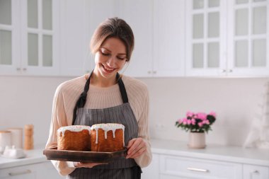 Geleneksel Paskalya pastaları olan genç bir kadın mutfakta, mesaj için yer var.