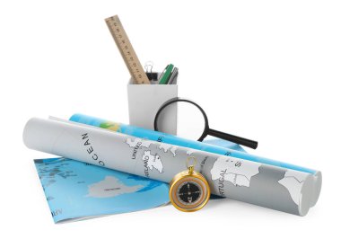 Yolculuk. Pusula, büyüteç, dünya haritaları ve kırtasiye malzemeleri beyaza izole edilmiş.