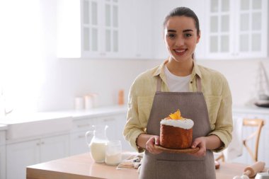 Mutfakta geleneksel paskalya pastası olan genç bir kadın, mesaj için yer var.