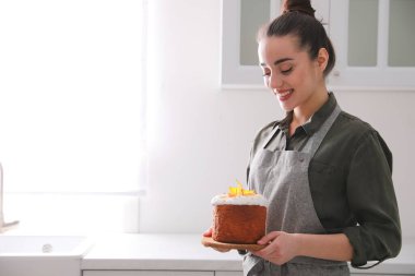 Mutfakta geleneksel Paskalya pastası olan genç bir kadın. Metin için boşluk