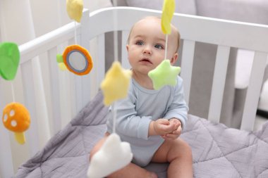 Evinde bebek karyolası olan küçük şirin bir bebek.