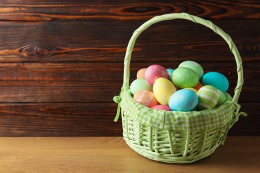 Tahta masadaki sepetteki güzel Paskalya yumurtaları. Metin için boşluk