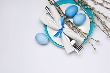 Paskalya kutlaması. Söğüt dalları ve beyaz arka planda boyanmış yumurtalarla bembeyaz masa ayarları. Metin için boşluk