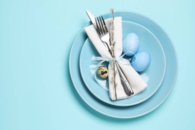 Paskalya kutlaması. Söğüt dallı şenlik masası ve açık mavi arka planda yumurtalar, üst manzara. Metin için boşluk