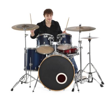 Elinde bagetlerle gülümseyen genç çocuk beyaz arka planda davul çalmayı öğreniyor.