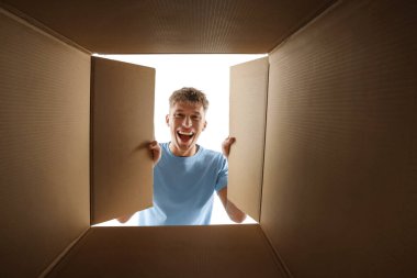 Adam beyaz arka planda karton kutuya bakıyor, içeriden görüntüle