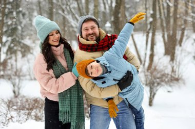 Mutlu aile, kış günü dışarıda birlikte vakit geçirir.