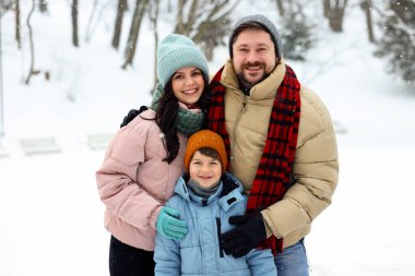 Kış günü açık havada mutlu bir aile portresi