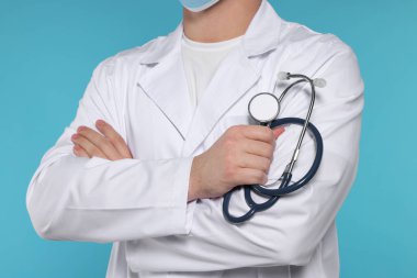 Açık mavi arka planda steteskobu olan doktor, yakın plan.