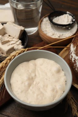 Hamur mayası ve malzemeler ahşap masada, yakın plan.