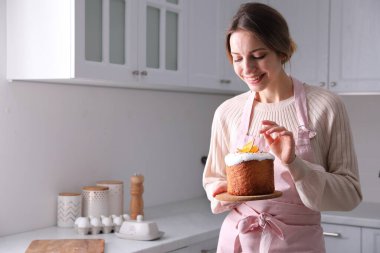 Mutfakta geleneksel paskalya pastası olan genç bir kadın, mesaj için yer var.