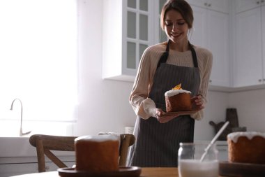 Mutfakta geleneksel paskalya pastası olan genç bir kadın, mesaj için yer var.