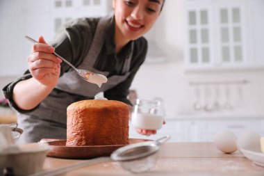 Geleneksel Paskalya pastasını mutfakta jöleli dekore eden genç kadın, eline odaklan.