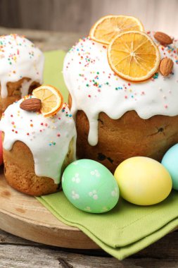 Nefis dekore edilmiş Paskalya pastaları ve yumurtalar ahşap masada, yakın plan.