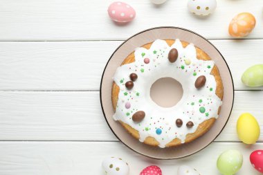 Lezzetli Paskalya pastası ve beyaz ahşap masaya boyanmış yumurtalar. Metin için boşluk