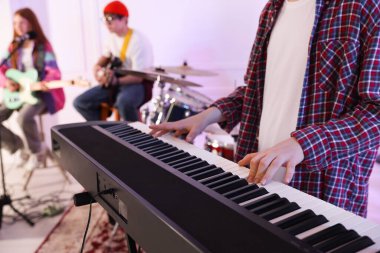 Genç müzik grubu kapalı alanda performanslarını prova ediyor, seçici odaklanma.