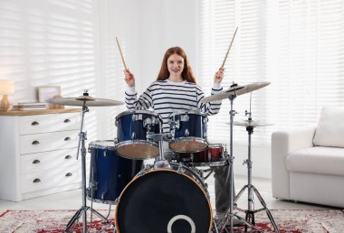 Davul çalmayı içeride öğrenen genç bir kız.