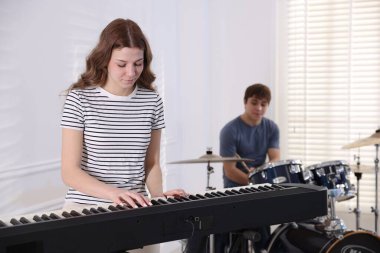 Genç müzik grubu içeride performanslarını prova ediyor.