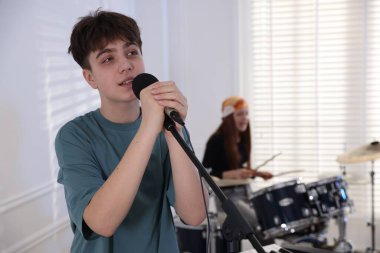 Genç müzik grubu kapalı alanda performanslarını prova ediyor, seçici odaklanma.