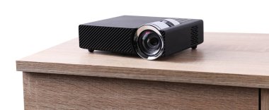 Bir modern video projektörü beyaz arka plana karşı ahşap masa üzerinde