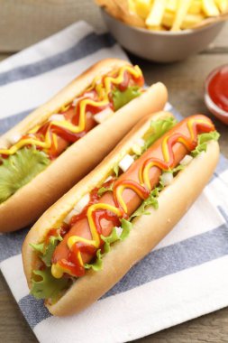 Ahşap masada soslu ve marullu lezzetli sosisliler, yakın plan.