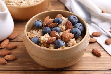 Bademli yulaf ezmesi ve ahşap masada yaban mersini, yakın plan.