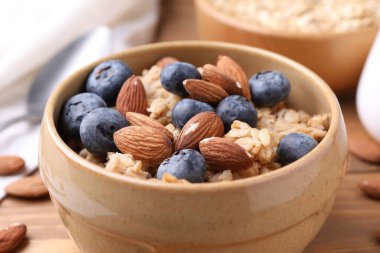 Bademli yulaf ezmesi ve ahşap masada yaban mersini, yakın plan.