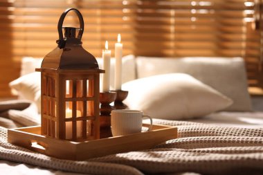 Güzel bir Noel feneri, yanan mumlar ve sıcak bir bardak içecekle kapalı bir yerde, yakın plan. Metin için boşluk