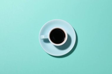 Turkuaz arka planda bir fincan aromatik kahve.