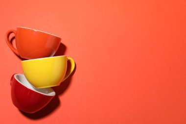 Kırmızı arka planda farklı kahve fincanları, düz yatış. Metin için boşluk