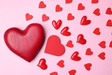 Sevgililer Günü. Pembe arka planda kırmızı dekoratif kalpler, düz uzanmış