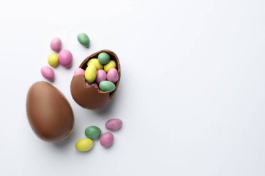 Beyaz arka planda çikolatalı Paskalya yumurtaları ve şekerler. Metin için boşluk