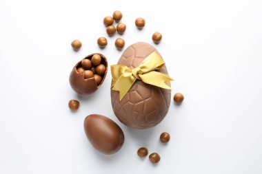 Beyaz arka planda çikolatalı Paskalya yumurtası ve şekeri, düz yatıyordu.
