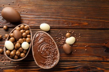 Mutlu Paskalyalar. Tahta masada şekerli, nefis çikolatalı yumurtalar. Metin için boşluk