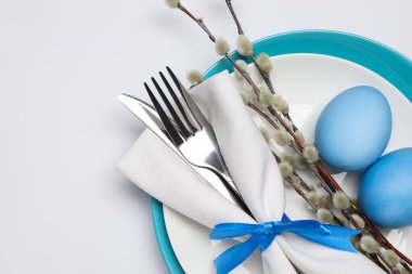 Paskalya kutlaması. Söğüt dalları ve beyaz arka planda boyanmış yumurtalar, üst manzara. Metin için boşluk