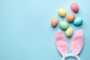 Mutlu Paskalyalar. Şirin tavşan kulakları ve açık mavi arka planda yumurtalar, düz bir şekilde yatıyordu. Metin için boşluk