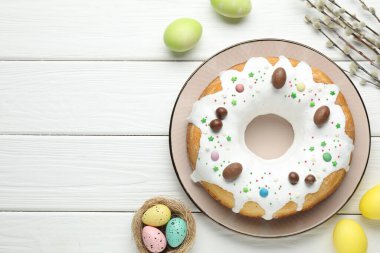 Lezzetli Paskalya pastası, boyanmış yumurtalar ve söğüt dalları beyaz ahşap masa, düz yatak. Metin için boşluk