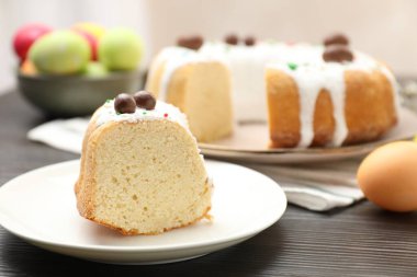 Paskalya pastasını kes ve ahşap masaya yumurta boya, yakın plan.