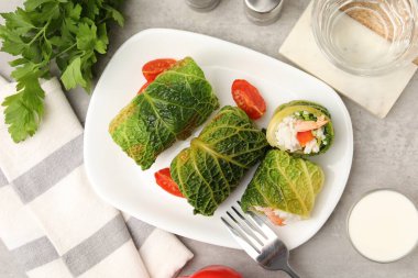 Gri masada servis edilen lezzetli lahana dürümleri.